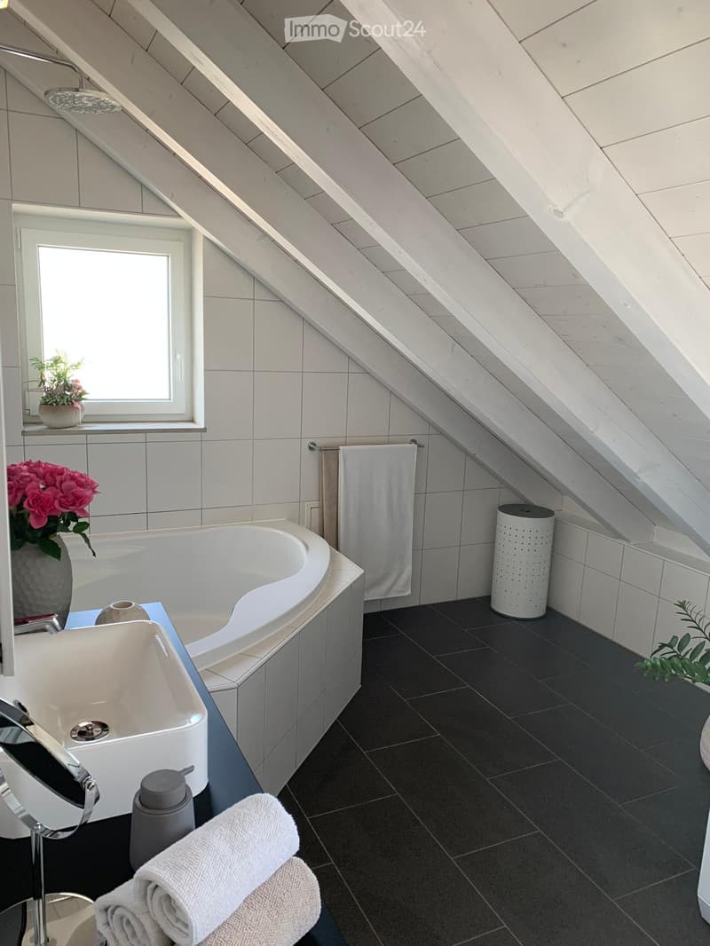 bathroom with bathtub, sink, tiles, window, flower vase, towel rack, white ceiling