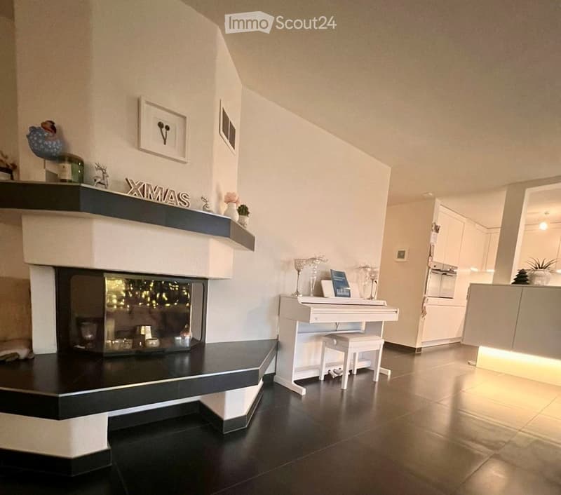 white walls, dark floors, central fireplace, white piano and stool, Christmas decorations