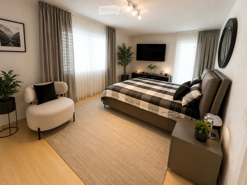 Modern bedroom with a large bed, nightstand, chair, mirror, table lamp, television, and potted plants.