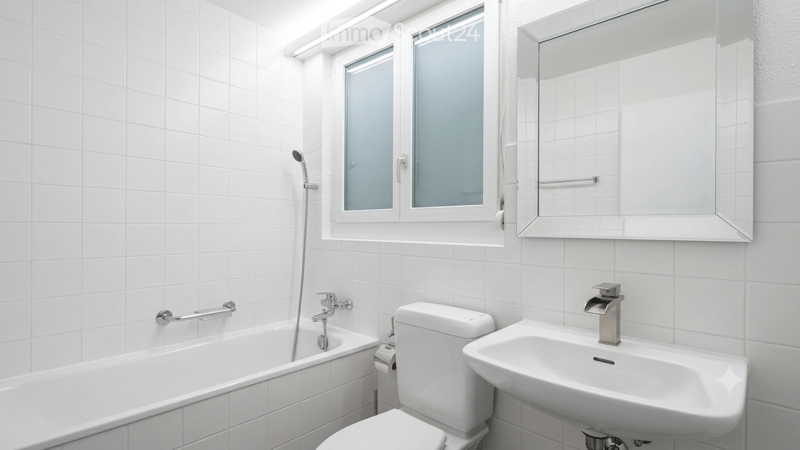 Modern bathroom with white tiled walls and floor, featuring a bathtub, toilet, sink, and large mirror. The window has frosted glass panes, and the fixtures are chrome.