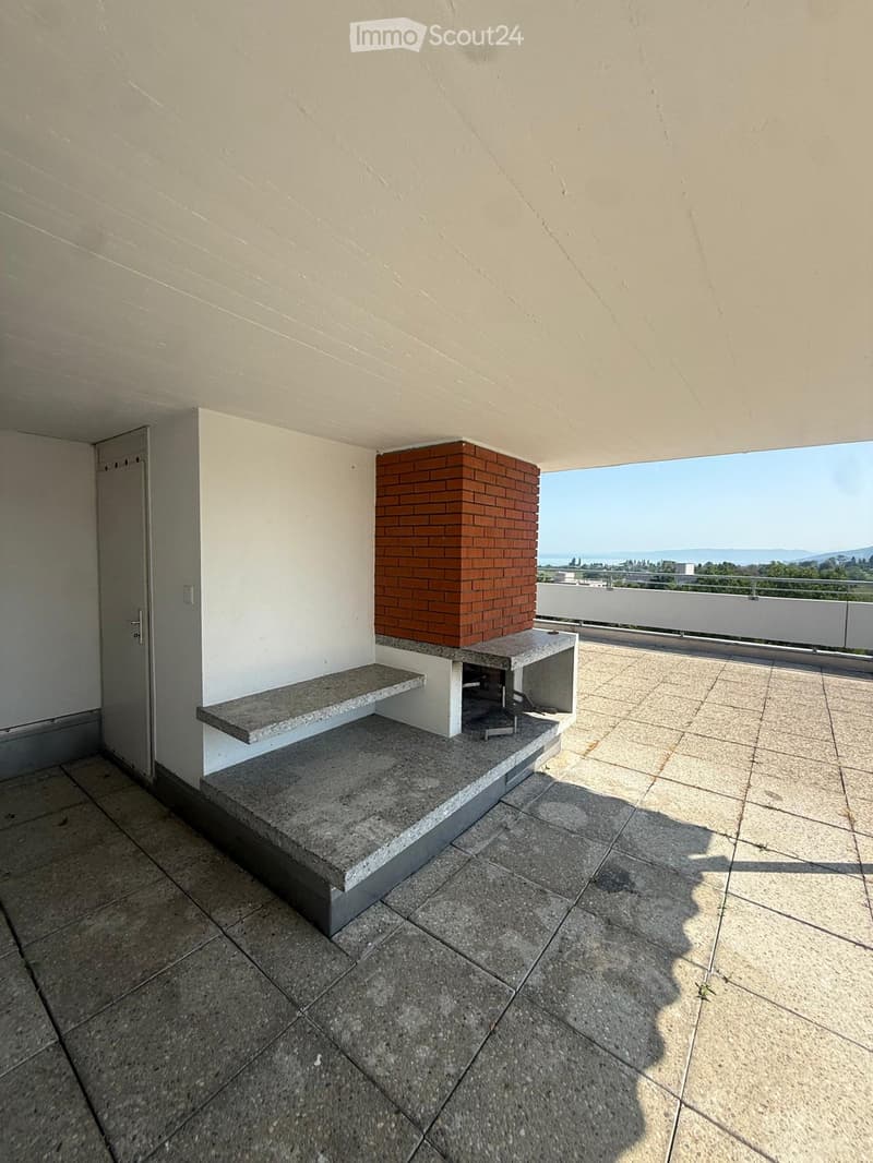 Balcony with tiled floor, stone bench, and scenic ocean view.