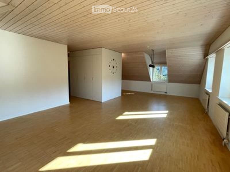 Completely empty room with wooden floor, white walls, and skylight windows. No furniture or equipment.
