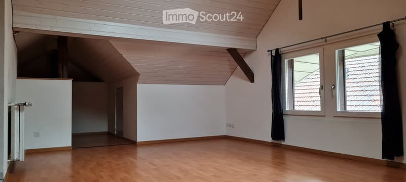 empty room with wooden floor, white walls, two windows, radiator