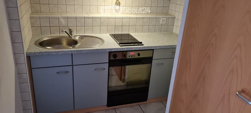 modern compact kitchen with ceramic tiles, built-in oven, dishwasher, stove top, and sink