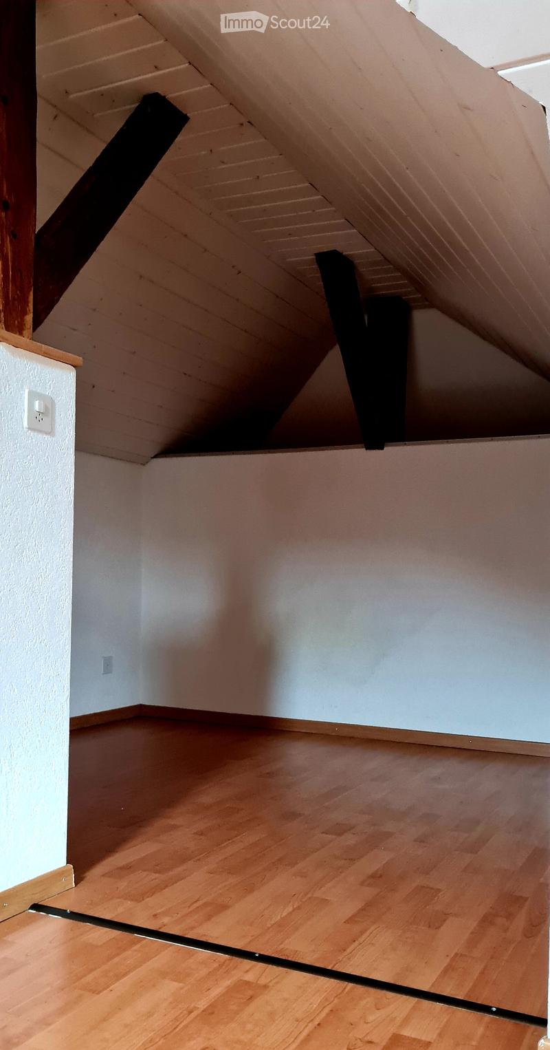 A empty room with wood floor, white ceiling, white walls