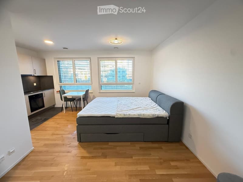 bedroom with bed, windows, and dining area