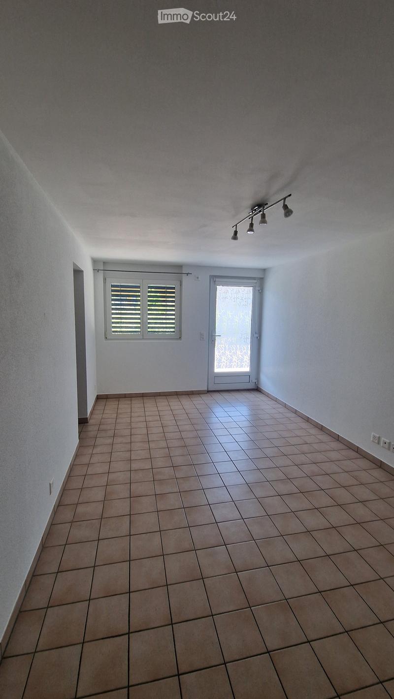 Empty room with tiled floor, white walls, and two doors with windows. No furniture or equipment present.