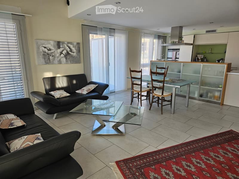 black sofas, coffee table, dining table with chairs, kitchen with open cabinets, glass door, window with blinds