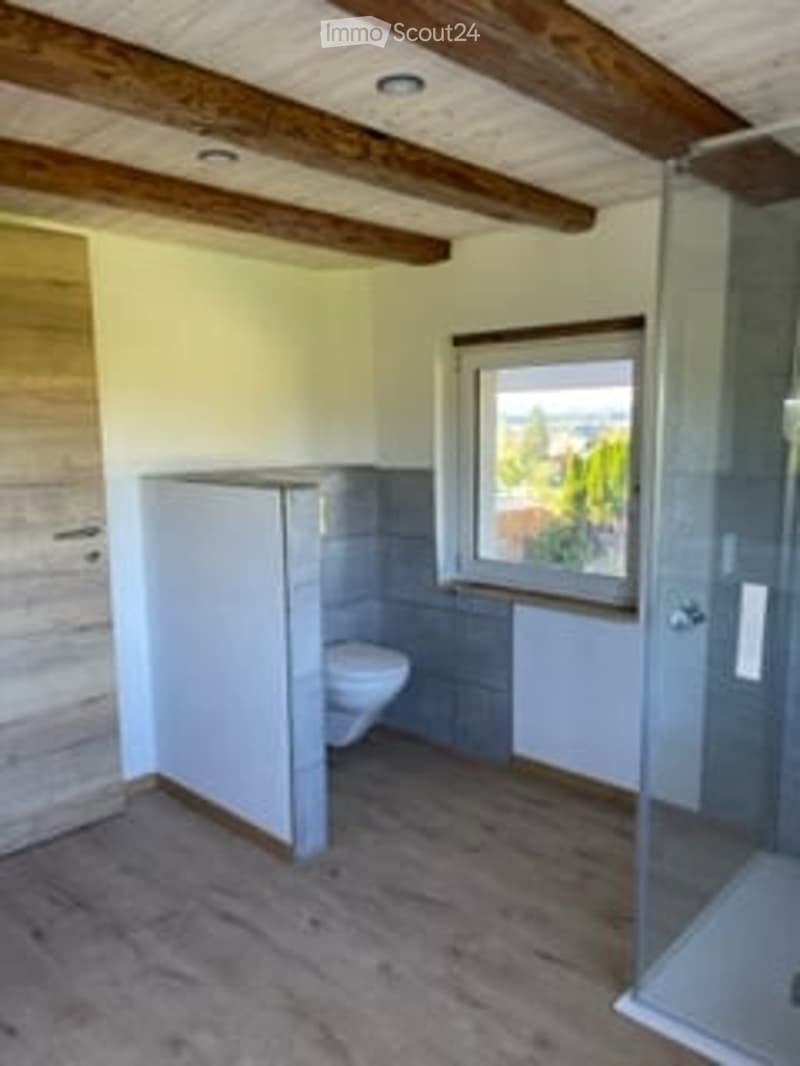 bathroom with toilet, shower, wooden floor