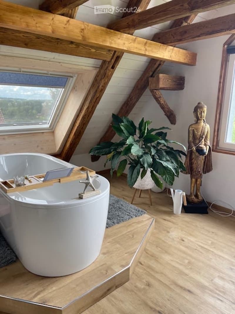free standing bathtub, Buddha statue, potted plant, wooden beams, rug