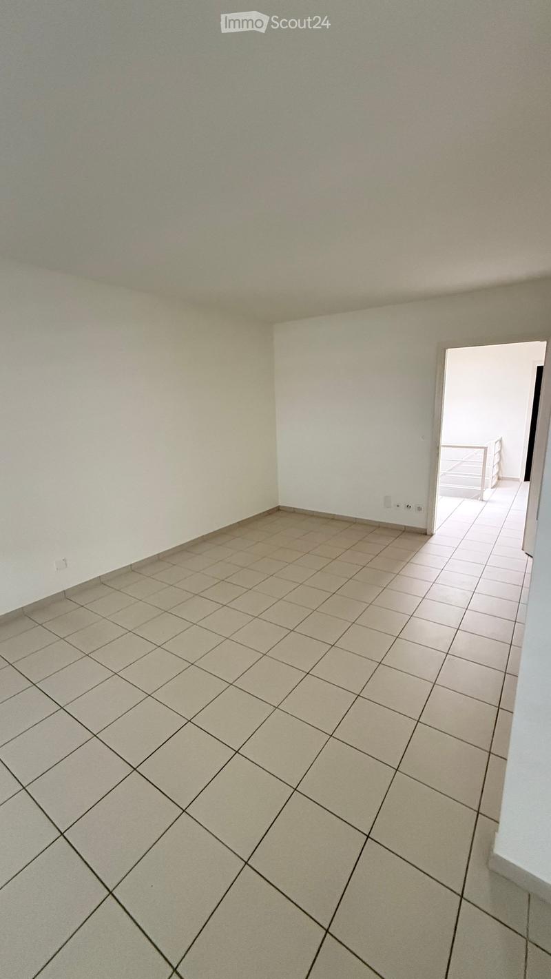 Empty room with tiled floor and white walls, featuring a doorway leading to another tiled area.