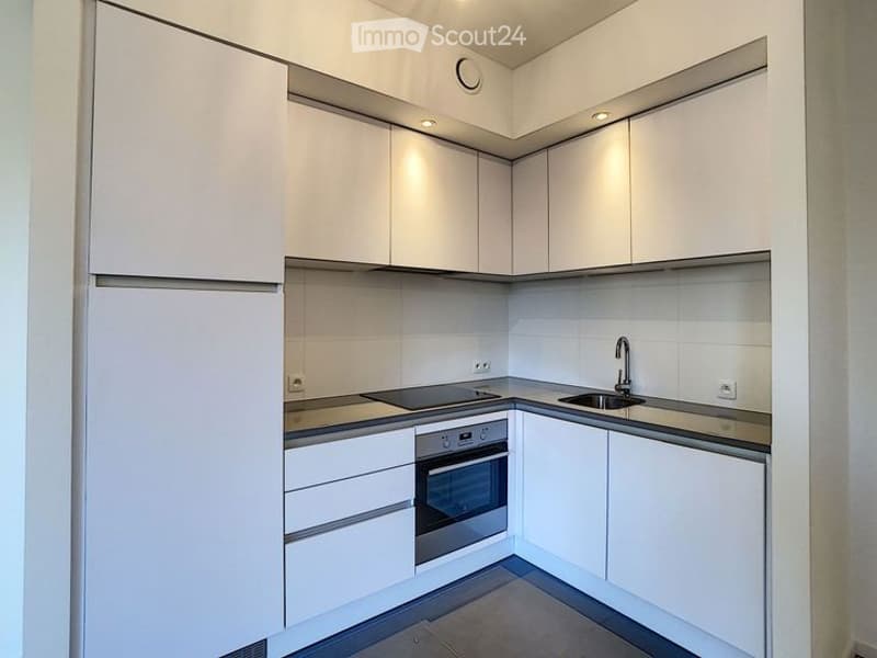 Modern, compact kitchen with white cabinets, stainless steel appliances, and a sleek design.