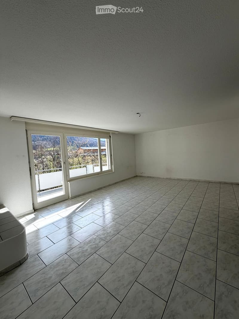 empty room, white walls, tiled floor, large glass door, balcony, view of trees and mountains