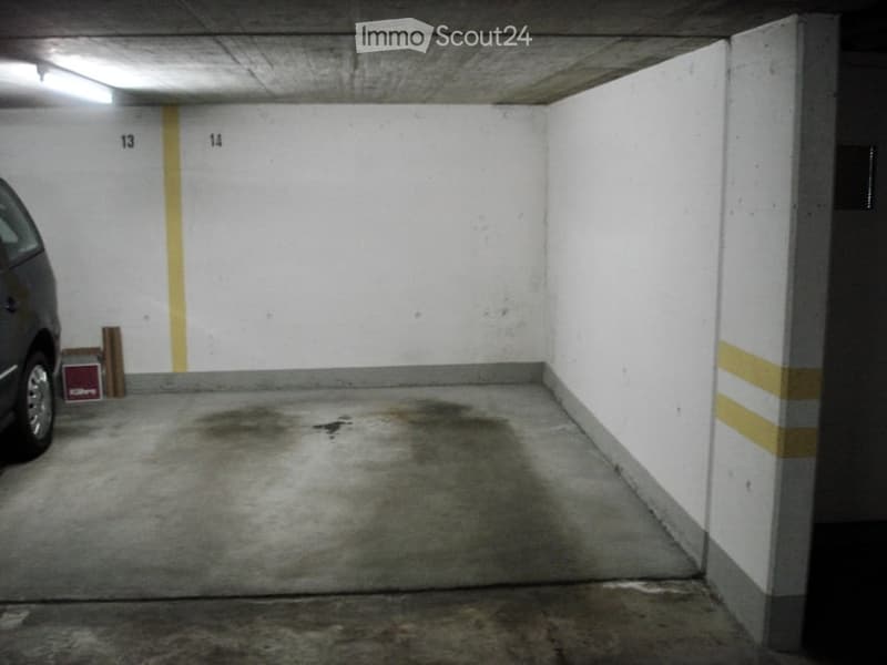 {"visible_features": ["Garage"], "type": "Garage", "objects": [], "description": "Underground parking space with white walls, concrete floor, and yellow painted lines marking parking spots. A car is partially visible on the left side.", "localized_descrip