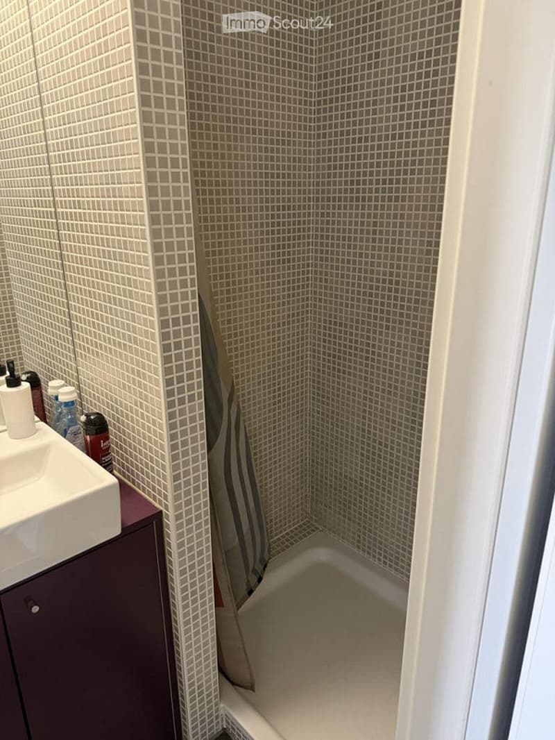 Small bathroom with a corner shower, tiled walls, a sink with a mirror, and a shower curtain.