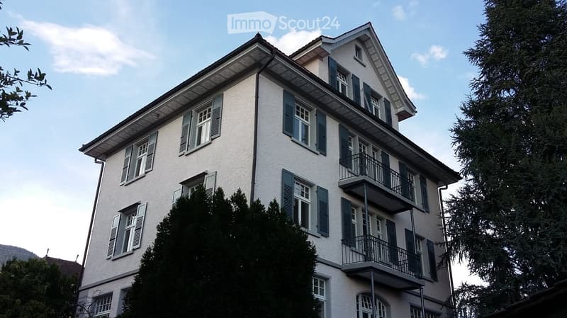 3 story house, white walls, blue shutters, balconies