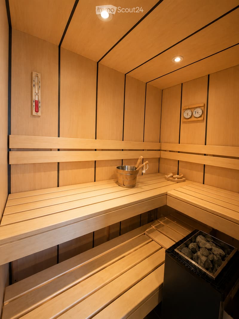 Wooden sauna with multiple benches, a metal bucket, wooden ladle, and a tray of rocks for heating.