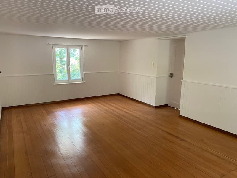 Empty room with wooden flooring, white walls, and a window with white frame. No furniture or equipment present.