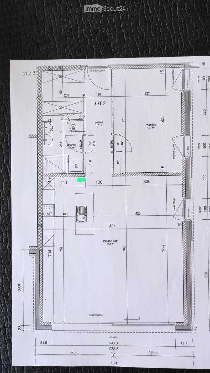 Floor plan of a residential space labeled 'LOT 2' with multiple rooms including an entrance, bedroom, bathroom, living space, and covered/uncovered areas.