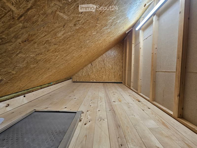 attic with wooden floor, wooden beams and white ceiling lights