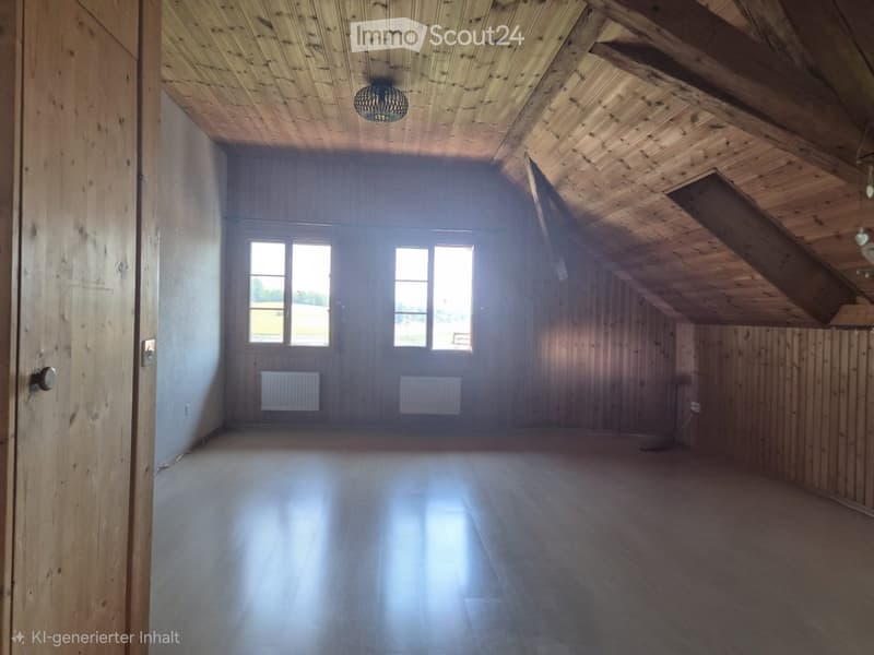 Empty attic space with wooden walls, ceiling beams, and large windows, featuring a smooth wooden floor and simple radiator heating.
