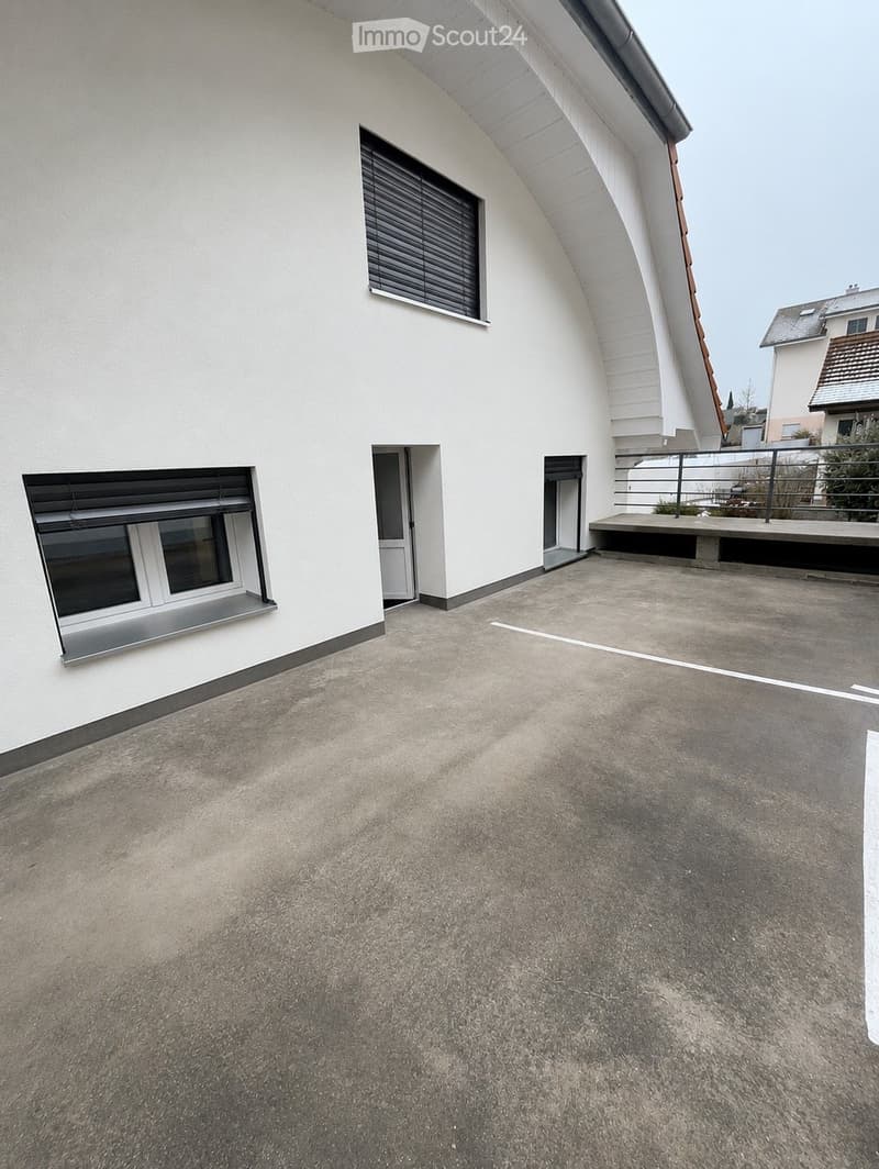 Roof terrace with concrete surface, metal railing, and access door to the building.