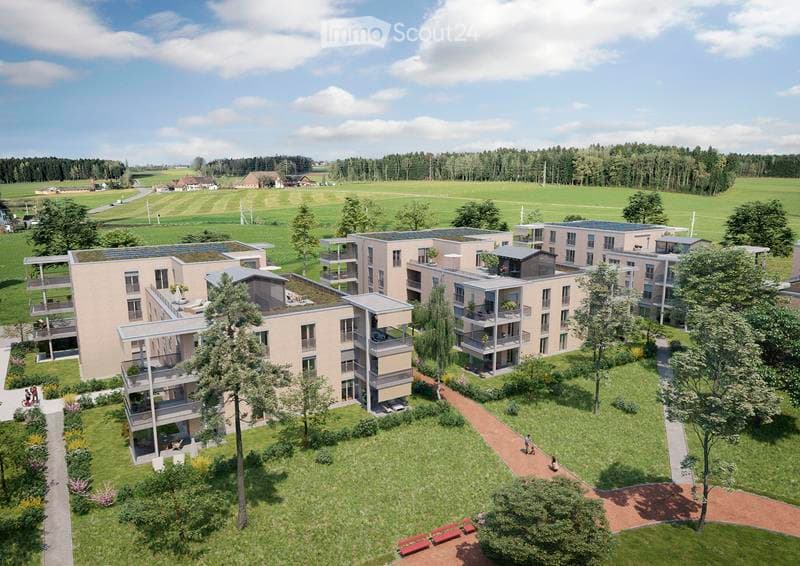 Building. Aerial view of a modern residential complex with multiple apartment buildings, green spaces, and pathways.