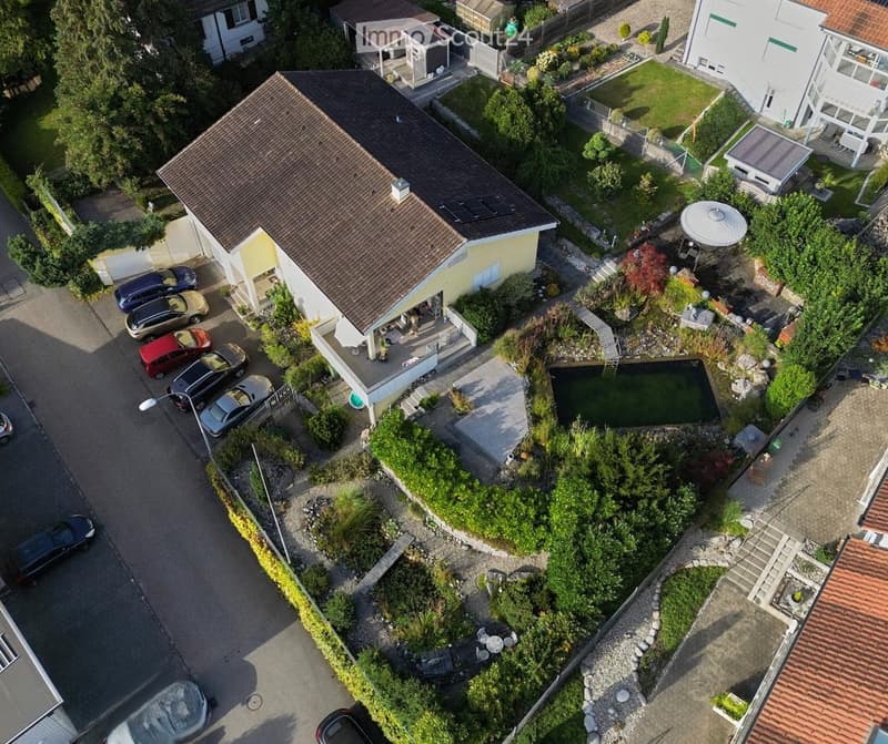 House with brown roof, yellow walls, multiple cars parked, swimming pool, garage