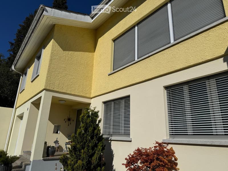 2 story house, yellow exterior, white windows, white trim, plants in front