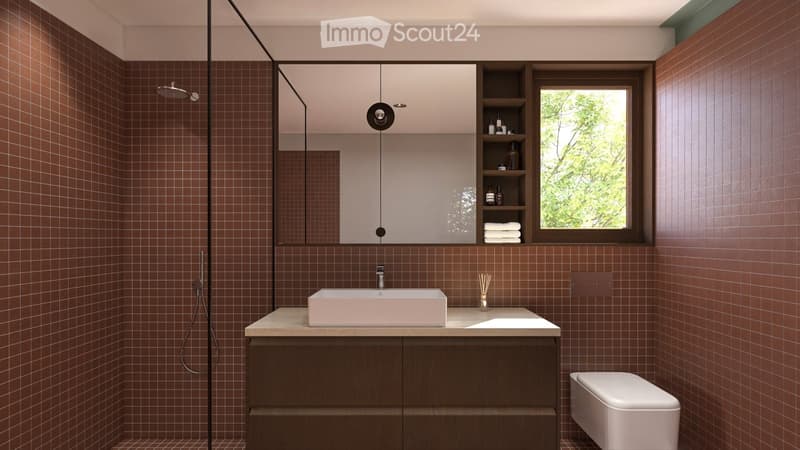 Modern bathroom with brown tiled walls, a white sink, a large mirror, a shower area, and a toilet. The space features a wooden cabinet and a window with a view of greenery.