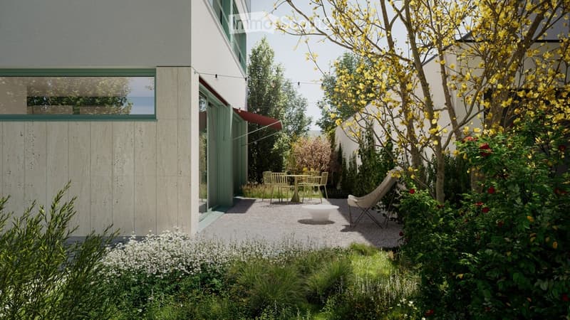 Modern outdoor patio area with a small seating arrangement, including a table and chairs, surrounded by lush greenery and flowering trees.