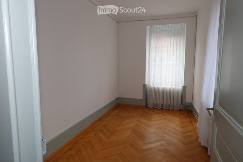 empty room, parquet flooring, white walls, window with white curtains