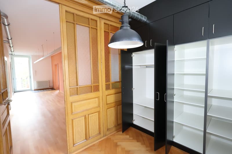 Empty room, hardwood floor, wooden door, wardrobe, two open closets, lamp