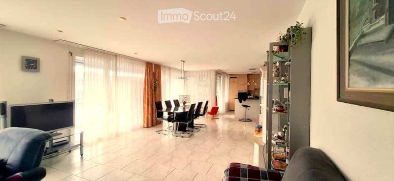 living room with dining area, white tiles, white walls, large windows, curtains, table, chairs, TV, cabinet, shelves, picture frame