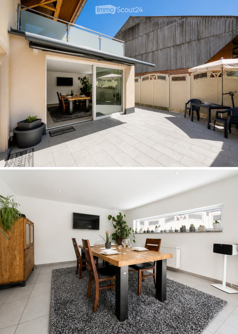 Balcony with tiled floor, outdoor dining table and chairs, umbrella, and indoor extension with a TV and dining area.