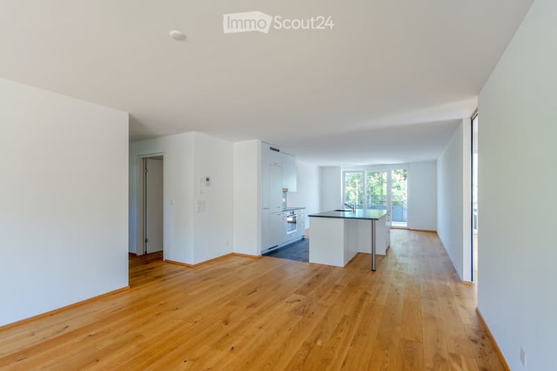 Empty room with wooden flooring, white walls, and a doorway leading to another space. No furniture or equipment is present.
