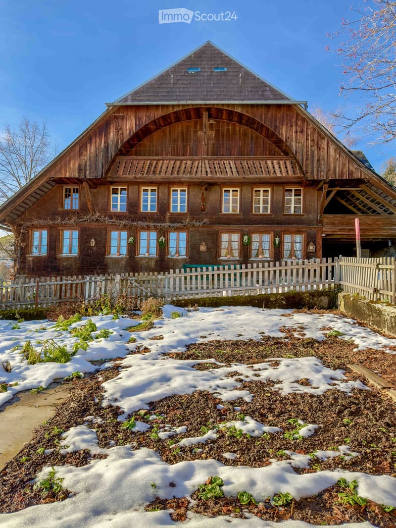 Traditional wooden house, multiple windows, wooden fence, snow on the ground
