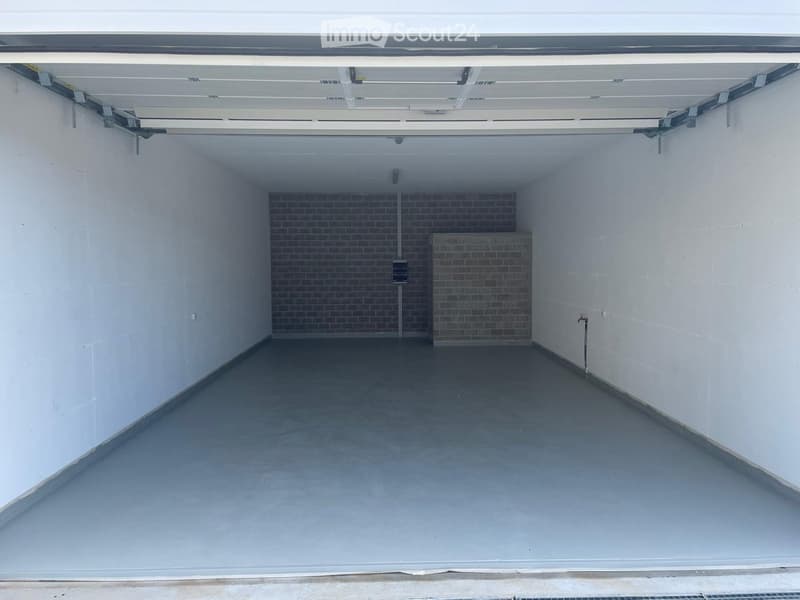 {"type": "Garage", "objects": [], "description": "Empty garage with white walls, concrete floor, and a brick pillar in the center.", "localized_descriptions": {"EN": "Empty garage with white walls, concrete floor, and a brick pillar in the center.", "DE":