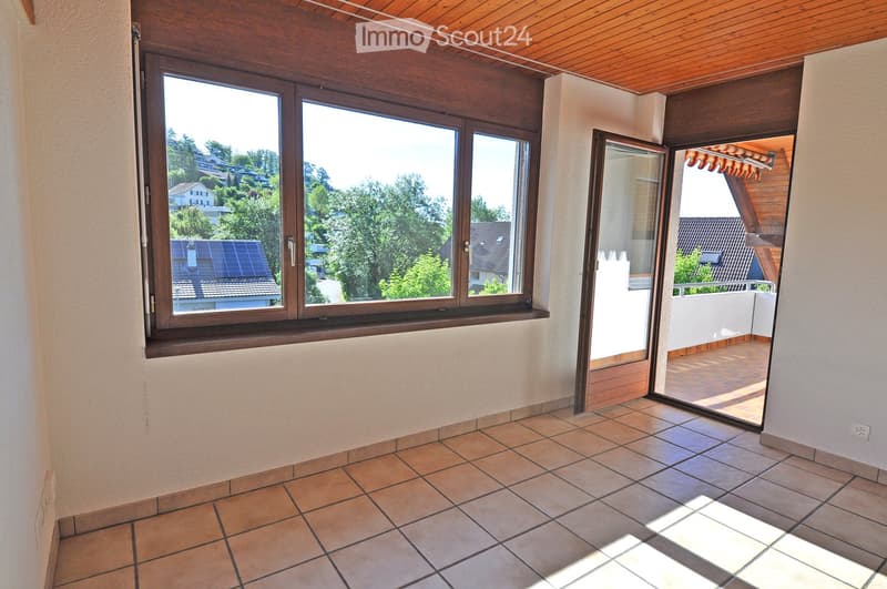 Empty room with tiled floor, large window, and sliding glass door leading to a balcony.