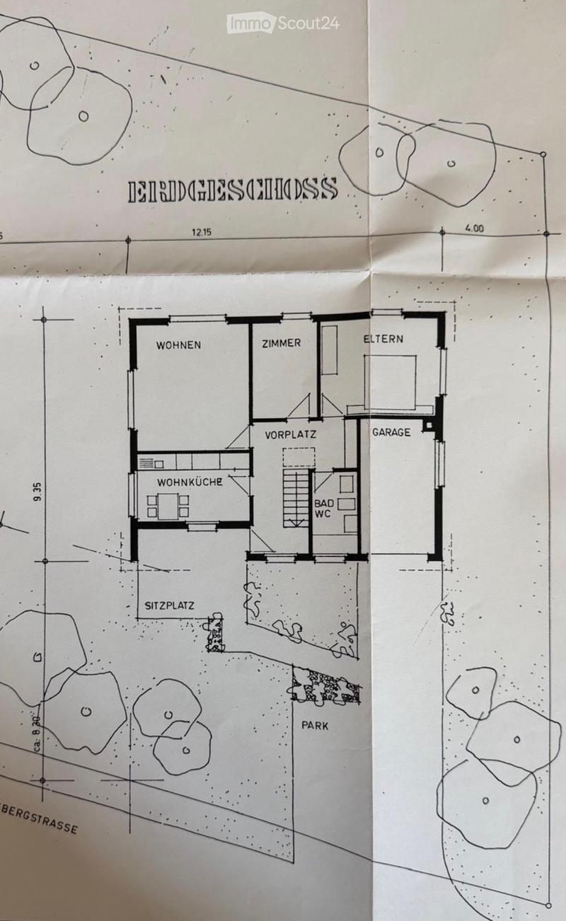 Floor plan showing a house layout with living room, bedroom, kitchen, bathroom, garage, and outdoor seating area.