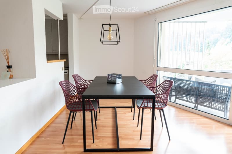 dining table with chairs, view through large windows, white walls, dark wood floor
