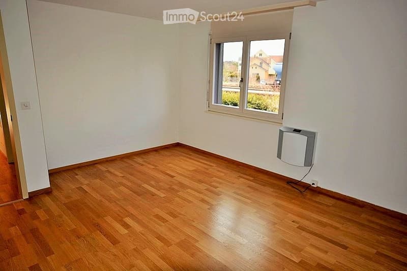 Empty room with wooden flooring, white walls, and a window with blinds. No furniture or equipment is present.