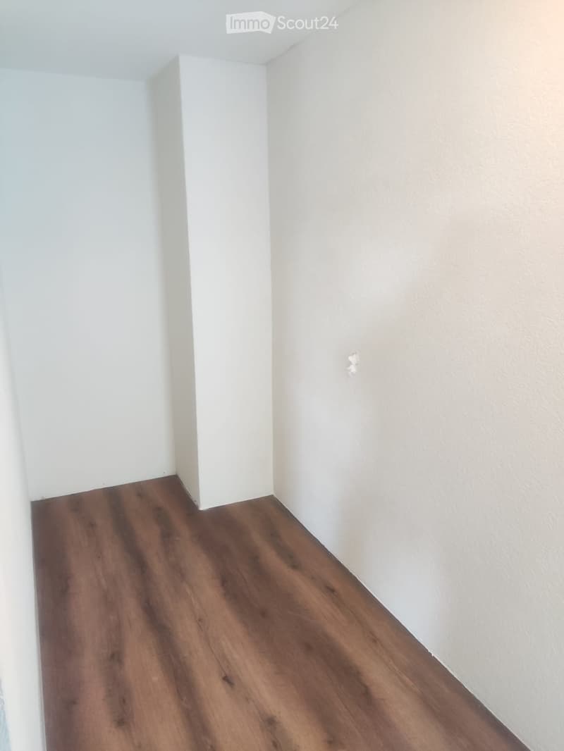 empty room, white walls, wooden floor, small pillar