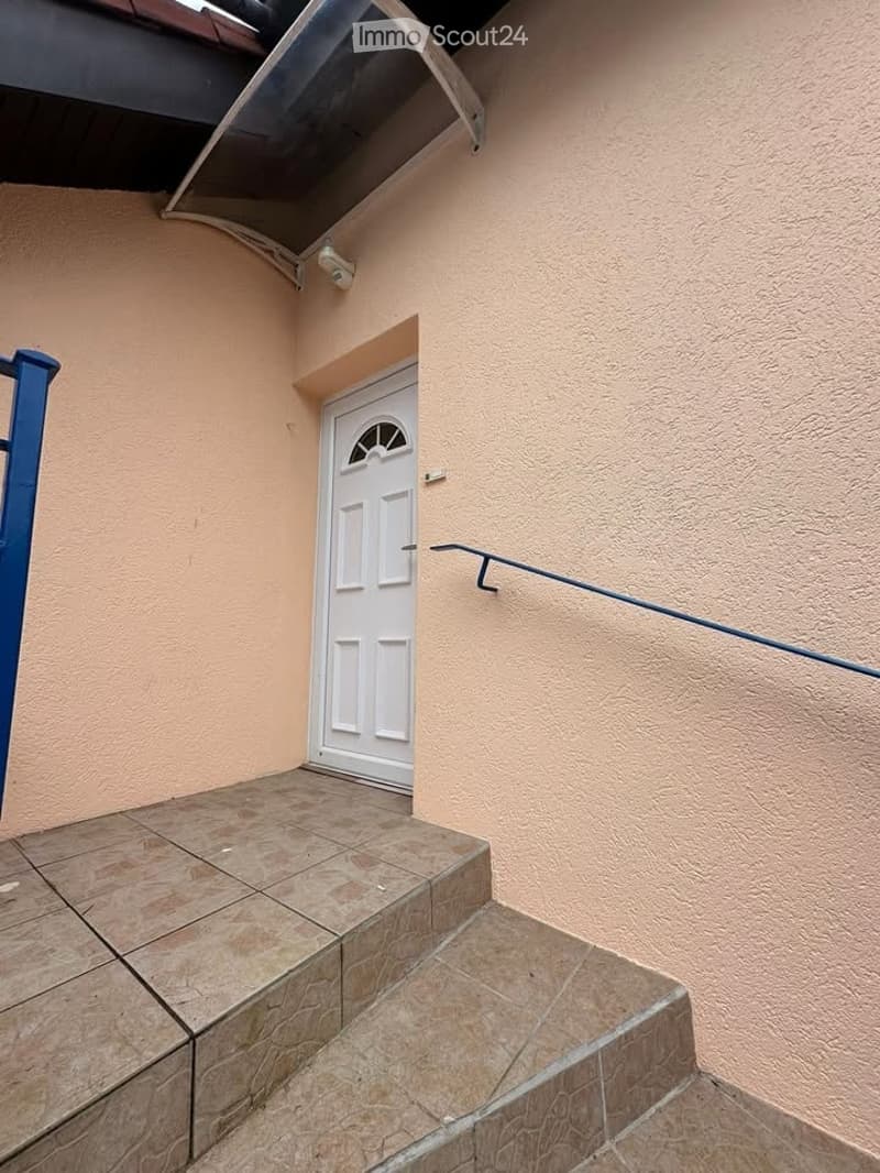 concrete steps, beige wall, white door, blue railing, security camera