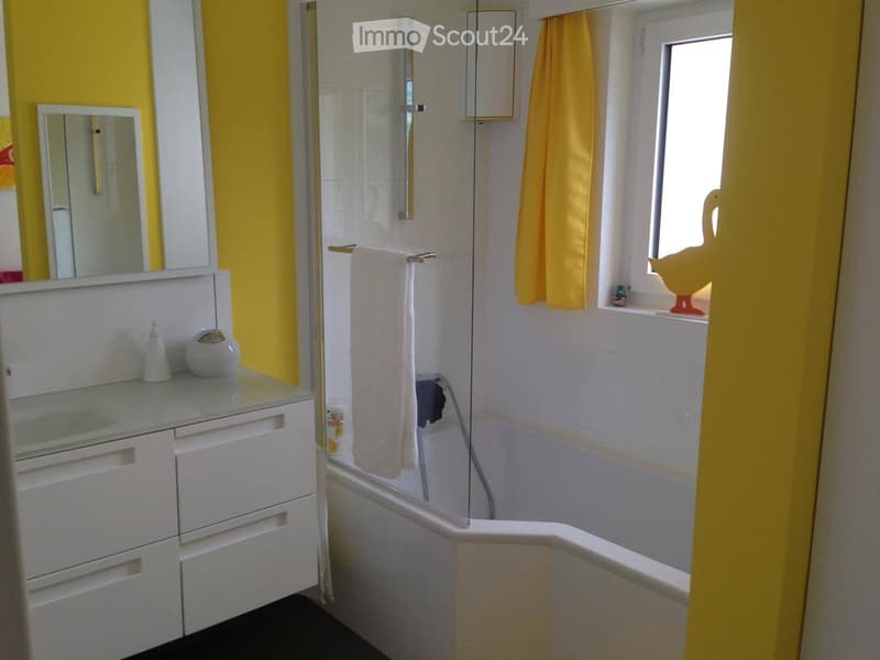 Bathroom. Bathroom with yellow walls, white tiles, a bathtub, a mirror, a towel, and a small cabinet with drawers.