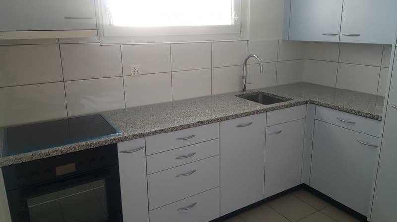 Modern kitchen, granite countertop, sink, electric stove, white cabinets, tile flooring