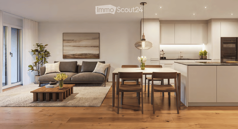 Open-plan living and dining area with a grey sectional sofa, wooden coffee table, dining table with chairs, modern kitchen with white cabinets and island, pendant light, artwork, and plants.