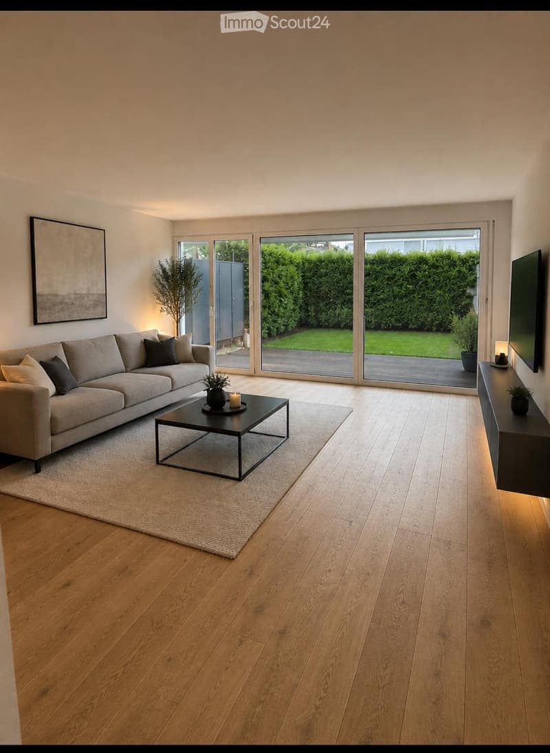 Modern living room with light wooden flooring, a grey sofa, a black coffee table, a TV stand, and large windows opening to a garden.