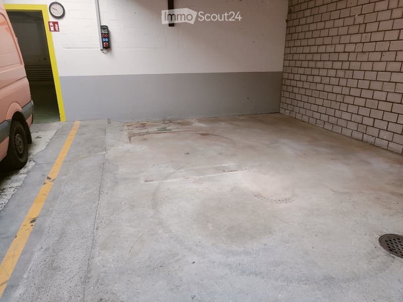 {"type": "Garage", "objects": [], "description": "Empty concrete garage with brick walls, a yellow-painted doorway, and a pink van partially visible on the left side.", "localized_descriptions": {"EN": "Empty concrete garage with brick walls, a yellow-pai