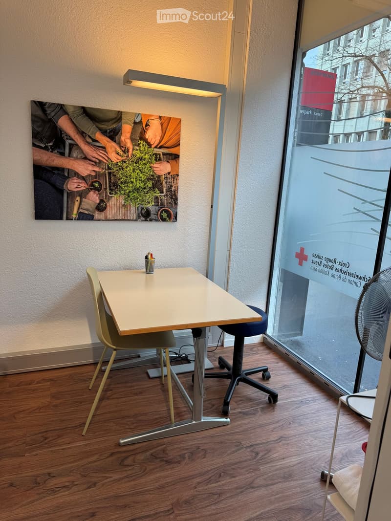 small room with a table, chairs, and a painting on the wall